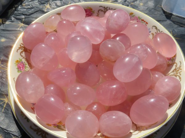 Pink quartz tumbled stones in a bowl.