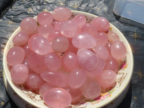 Pink rose quartz tumbled stones in a bowl.