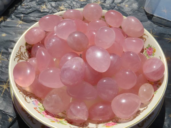 Pink rose quartz tumbled stones in a bowl.