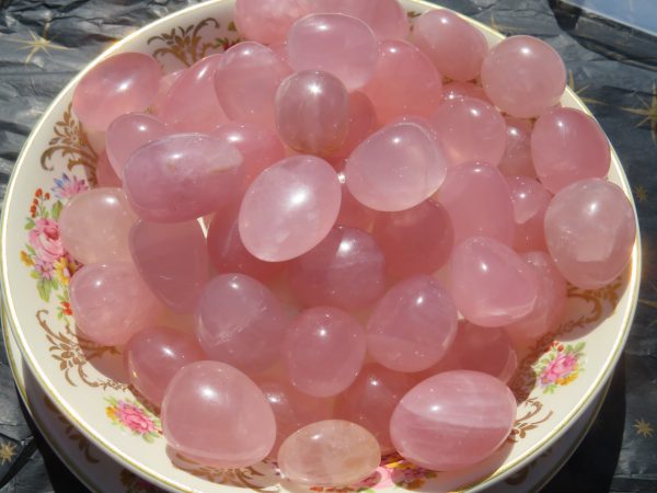 Pink rose quartz tumbled stones in bowl.
