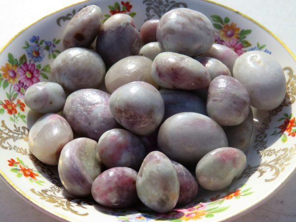 Purple and white tumbled stones in a dish.