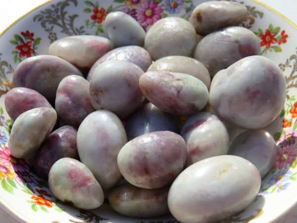 Smooth, white, and purple stones in a bowl.