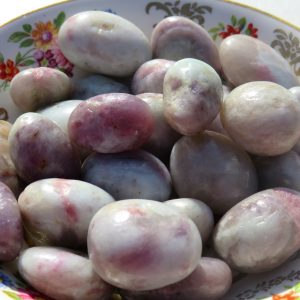 Purple and white tumbled stones in bowl.