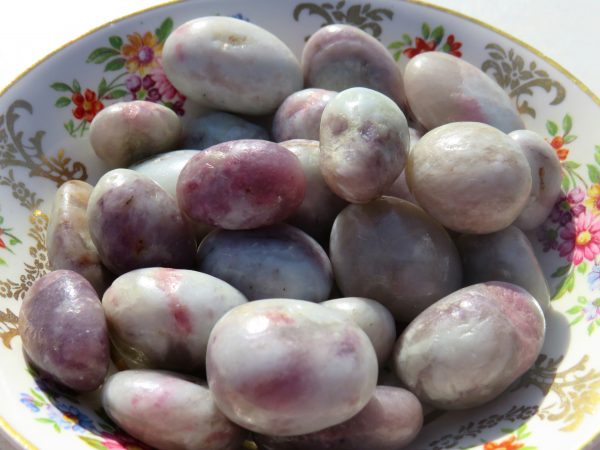 Purple and white tumbled stones in bowl.