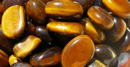 A pile of polished tiger's eye gemstones.