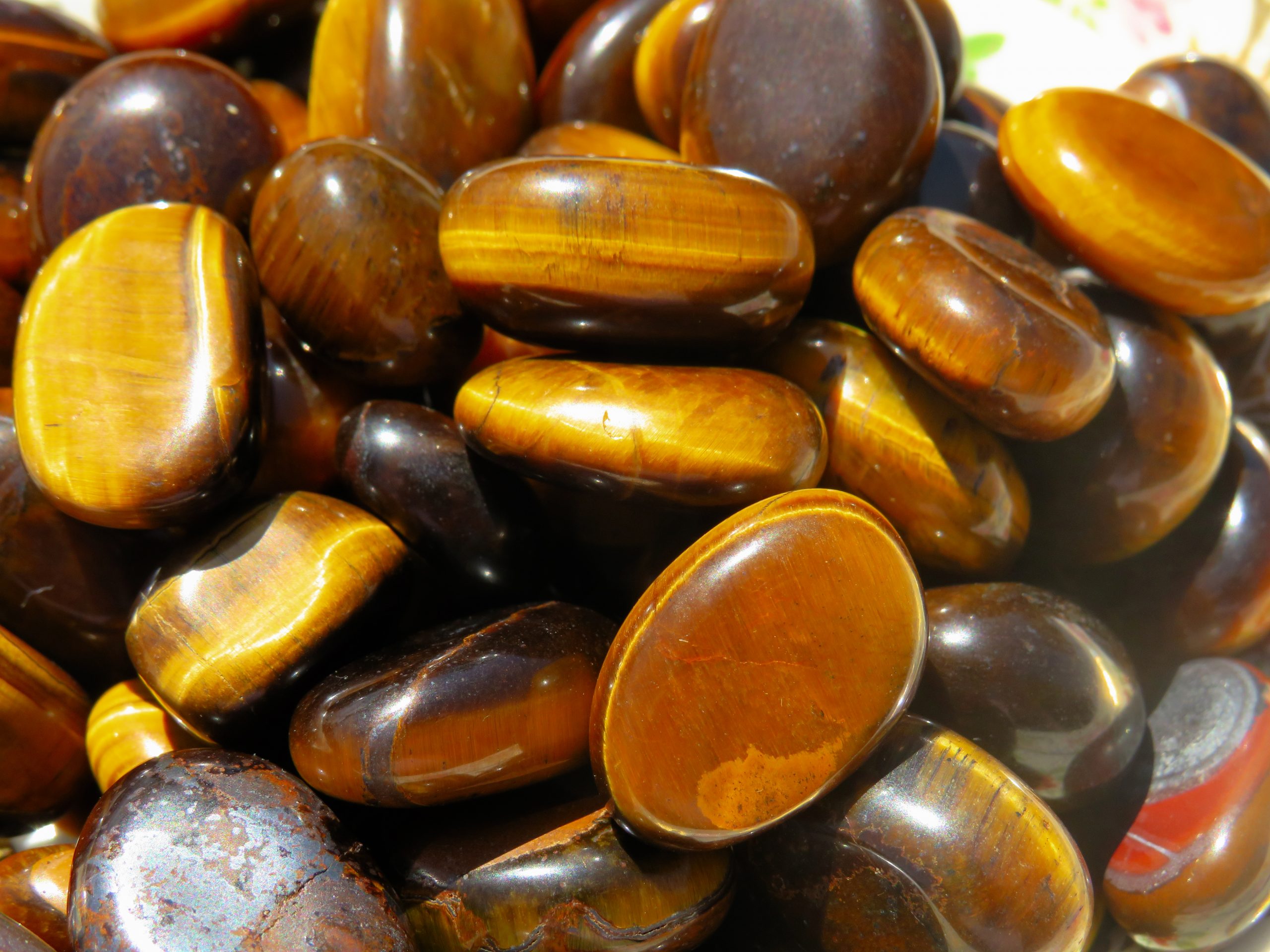 A pile of polished tiger's eye gemstones.