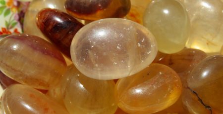 A pile of smooth, yellow gemstones.