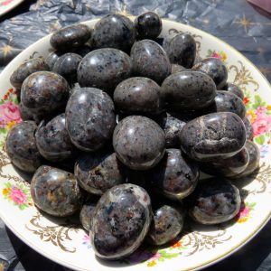 Smooth black and grey stones on a plate.