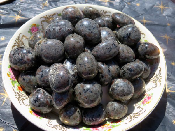 Black and grey tumbled stones on a plate.