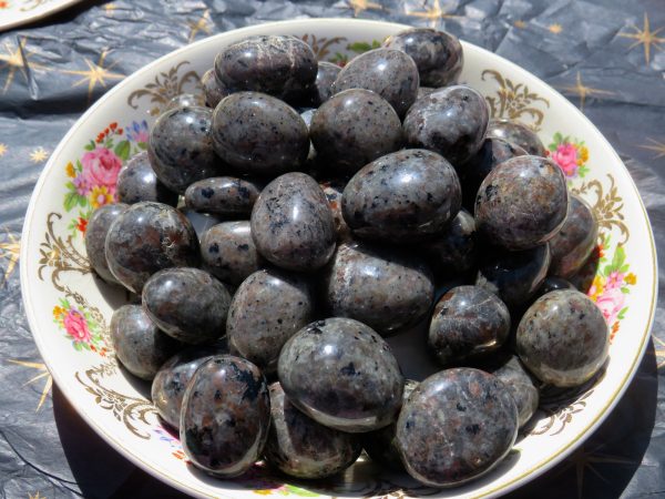 Black and gray polished stones in a bowl.