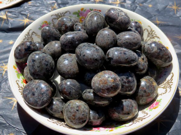 Black and grey tumbled stones in a bowl.
