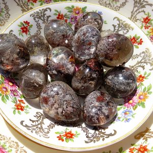 Smoky quartz tumbled stones on a plate.