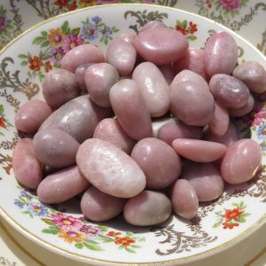 Pink stones in a floral patterned dish.