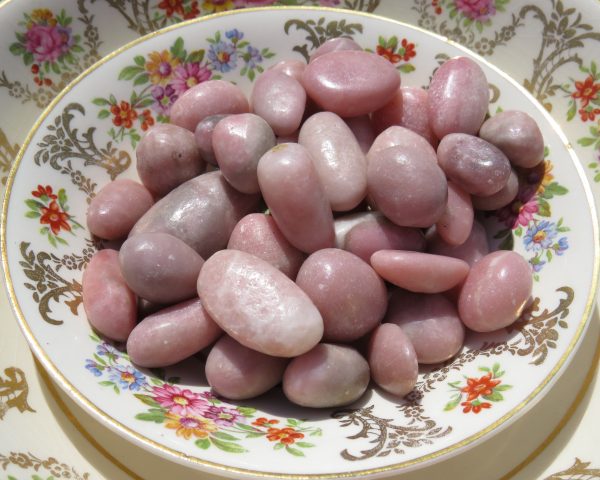 Pink stones in a floral patterned dish.