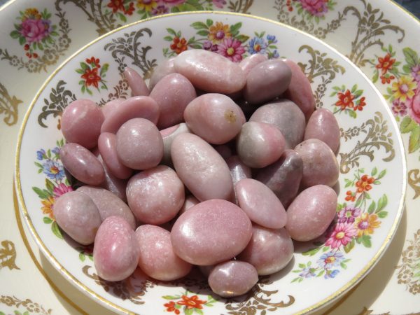 Pink and white stones on a floral plate.