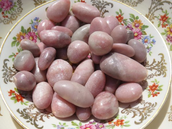 Pink and gray tumbled stones on plate.