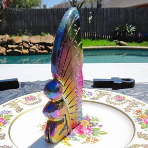 Iridescent glass butterfly on floral plate.