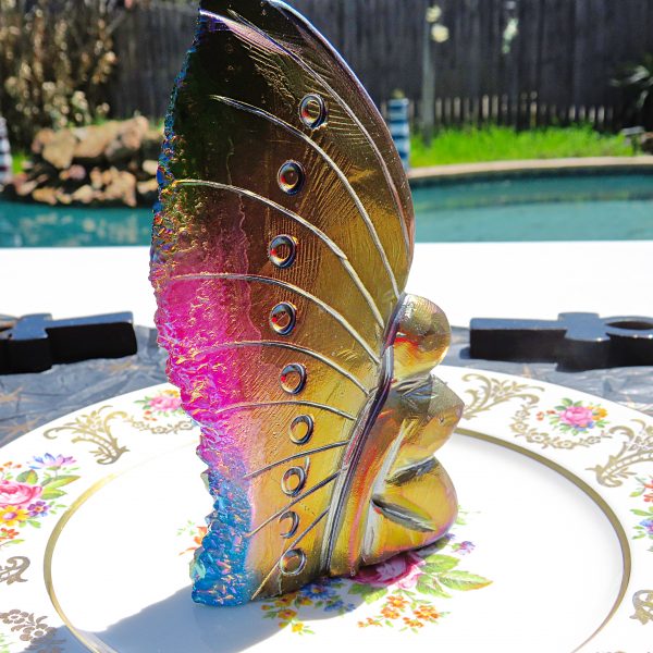 Iridescent glass butterfly on a plate.