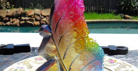 A plate with a Natural Rainbow Angel Aura Fairy with Rainbow Cluster Quartz on it.