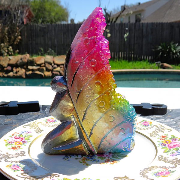 A plate with a Natural Rainbow Angel Aura Fairy with Rainbow Cluster Quartz on it.