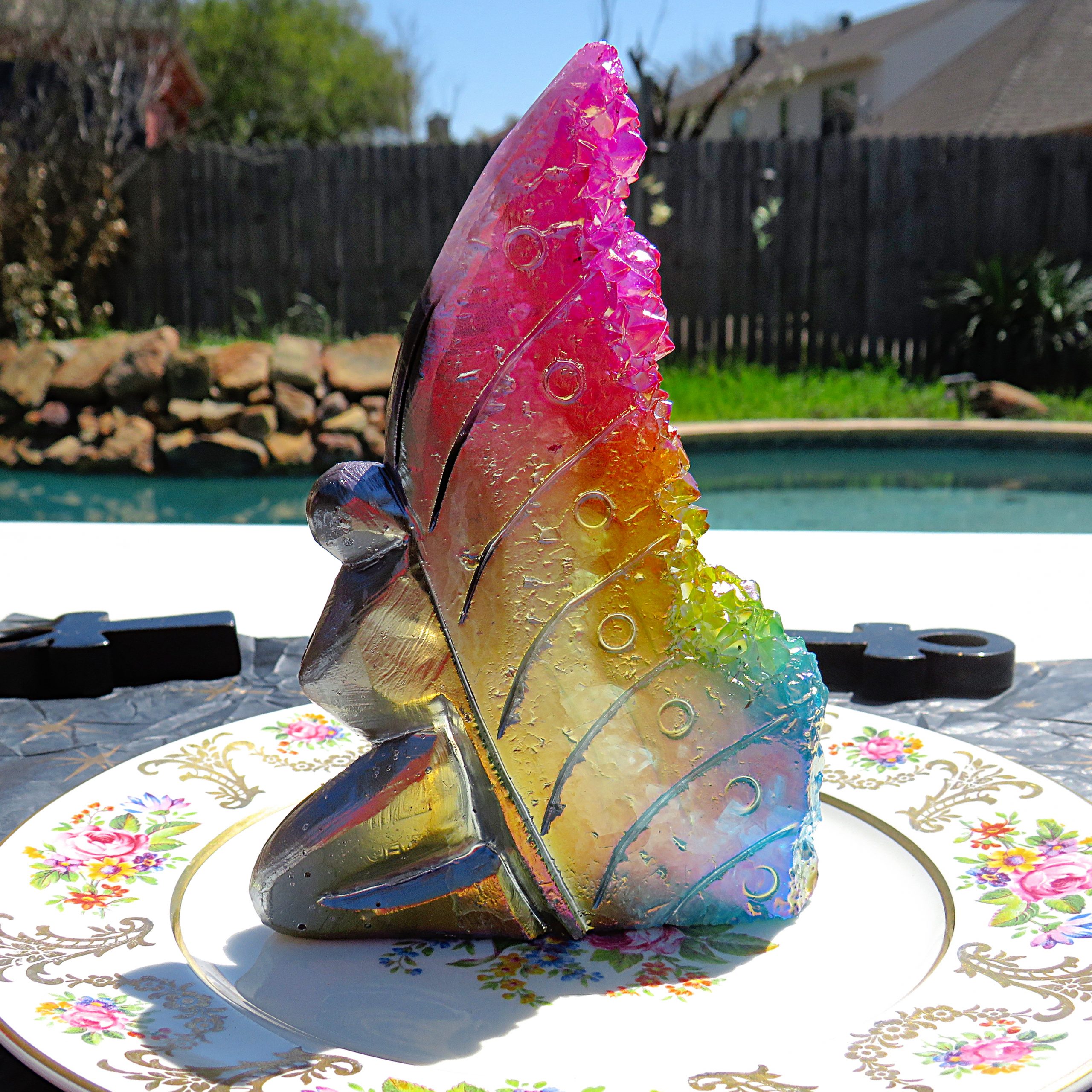 A plate with a Natural Rainbow Angel Aura Fairy with Rainbow Cluster Quartz on it.