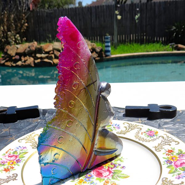 Colorful iridescent glass sculpture on plate.