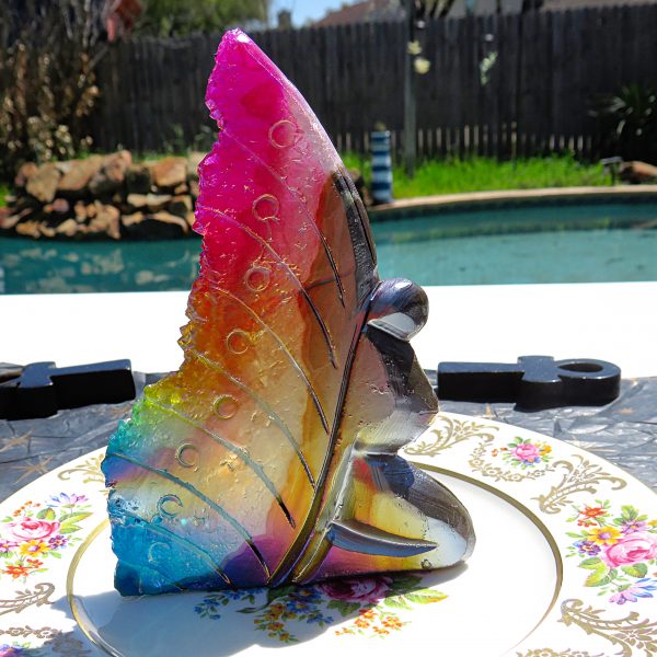 Rainbow iridescent glass sculpture on plate.
