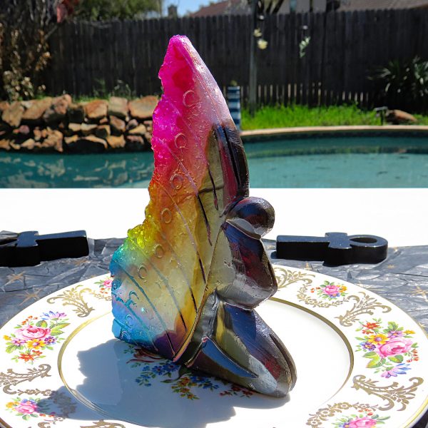 Rainbow crystal sculpture on floral plate.