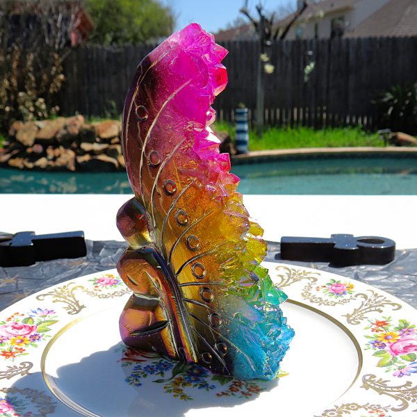 Rainbow iridescent crystal on floral plate.