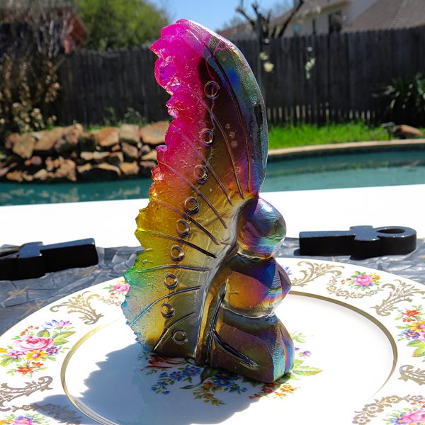 Rainbow iridescent glass sculpture on plate.