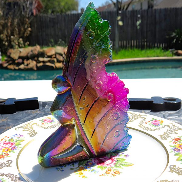 Iridescent glass butterfly on a plate.