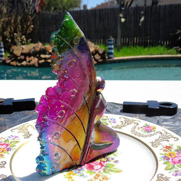 Iridescent butterfly crystal on floral plate.