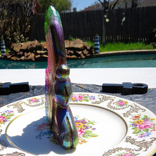 Iridescent glass sculpture on a floral plate.