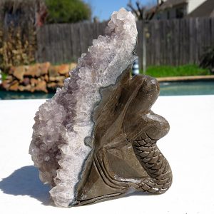 Carved amethyst crystal with wooden base.