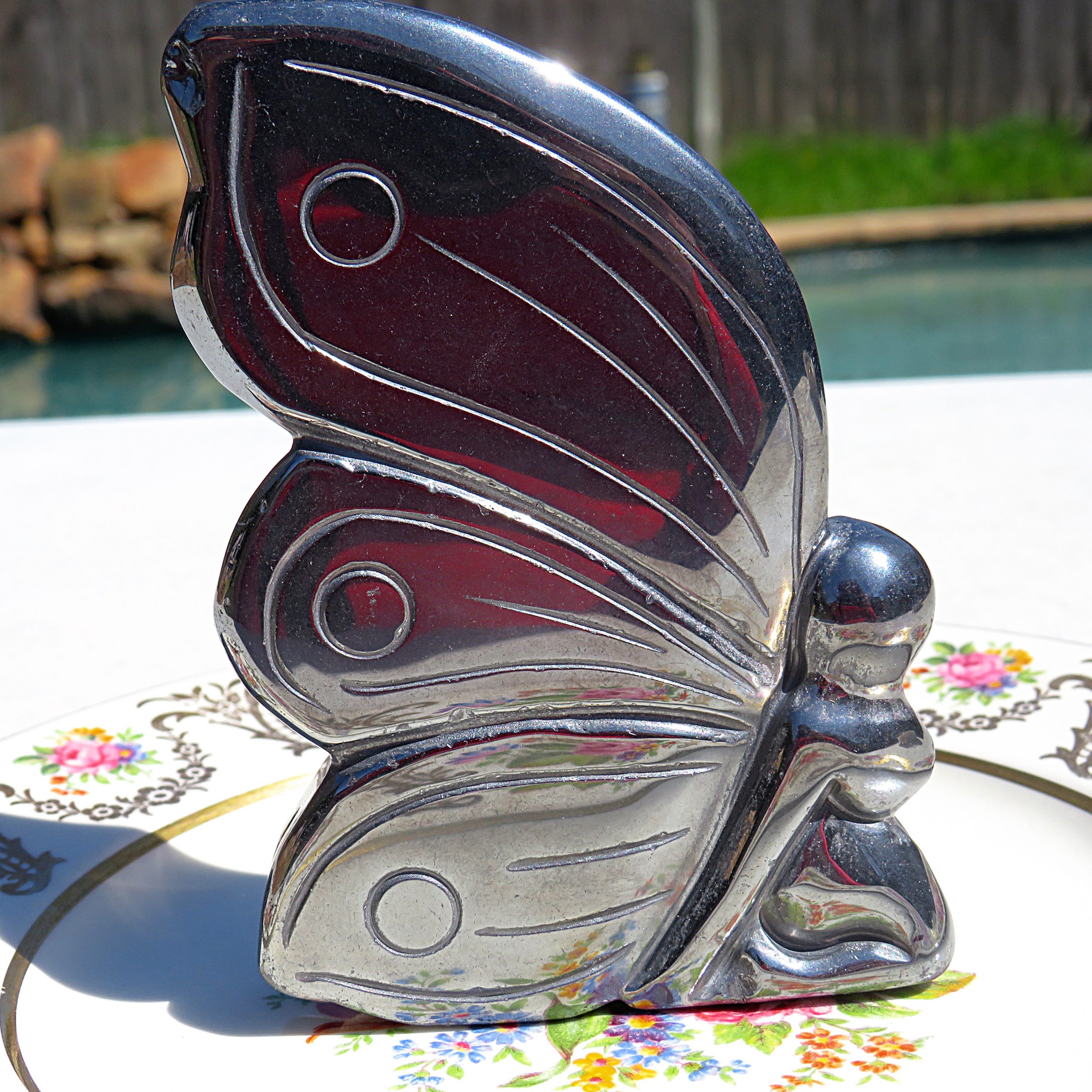 A Terahertz Fairy Carving sits on a plate next to a pool.