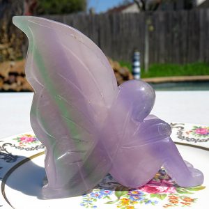 Purple fluorite fairy figurine on plate.