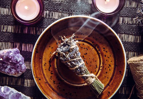 A bundle of dried lavender on a brown plate.