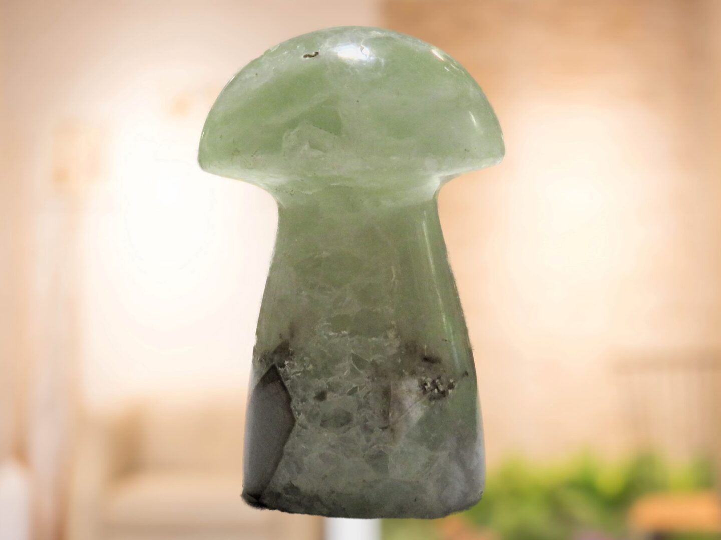 A green jade mushroom sitting on a table in a living room.