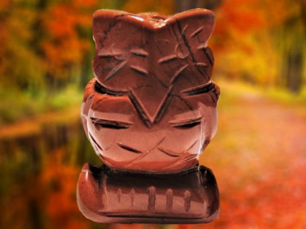 Red gemstone owl figurine carved in detail.