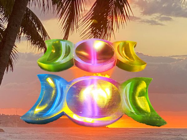 Three crescent moon bowls on beach at sunset.