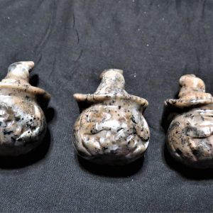 Three carved stone pumpkin figures.