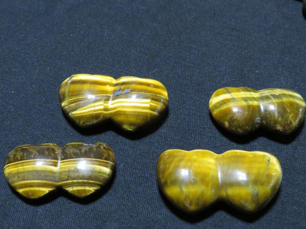 Four polished tiger's eye heart stones.