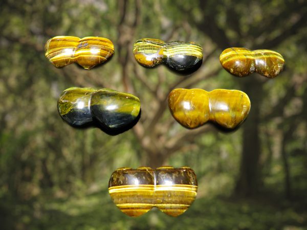 Five tiger's eye stones against green blur.