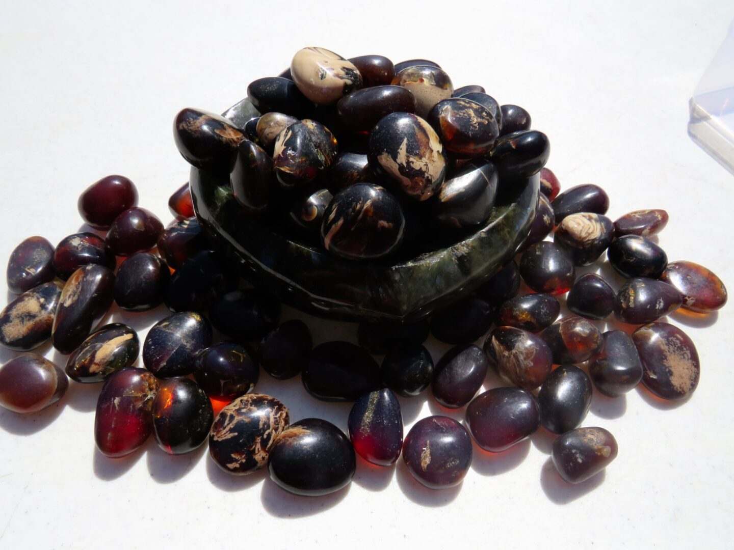 A bowl of black and brown beans on top of a white surface.