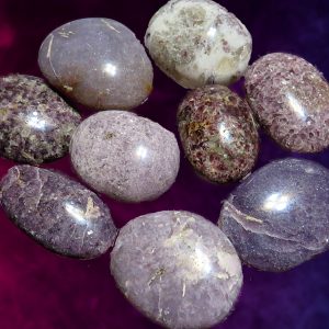 Collection of smooth, purple lepidolite stones.