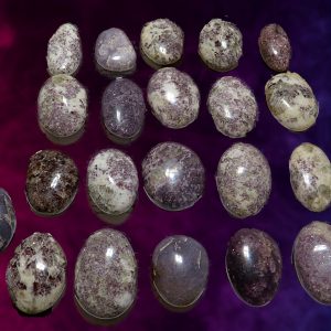 Collection of polished purple lepidolite stones.