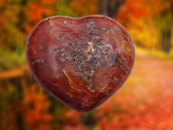 Heart-shaped carnelian gemstone with brown patterns.