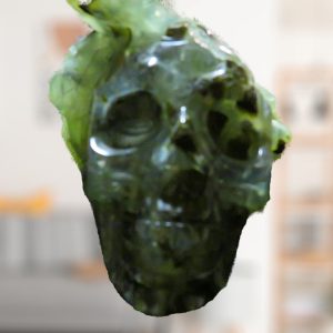 Green skull sculpture in a blurry room.