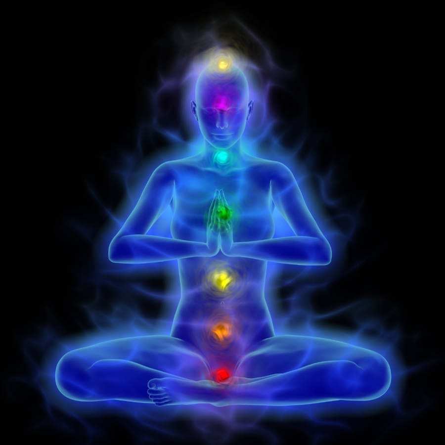 A woman in a lotus position with seven chakras image