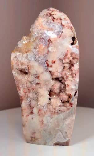 A piece of pink and white rock on top of a white table.